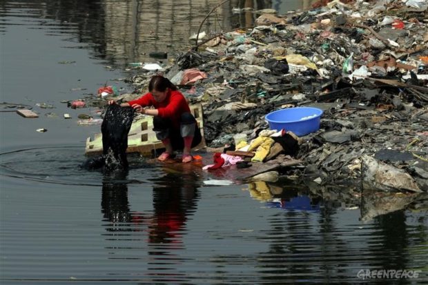 เมืองกุ้ยอวี๋ที่กำลังจะตายอันเนื่องจากเป็นศูนย์กลางการรีไซเคิลขยะพิษปริมาณมหาศาล ที่มาภาพ : http://www.greenpeace.org/eastasia/Global/eastasia/photos/toxics/ewaste/guiyu-woman-river.jpg